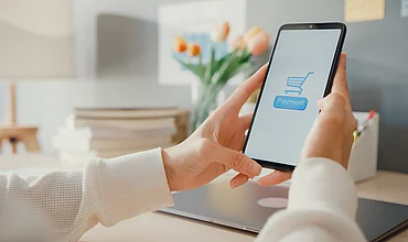 Frau bestellt am Smartphone online, Symbolbild zum Widerrufsbutton