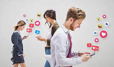 Menschen schauen auf ihre Smartphones, Symbolbild zu Reichweite in sozialen Netzwerken