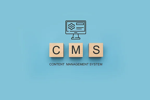 Holzwürfel mit den Buchstaben CMS, Symbolbild zum Vergleich von Content-Management-Systemen